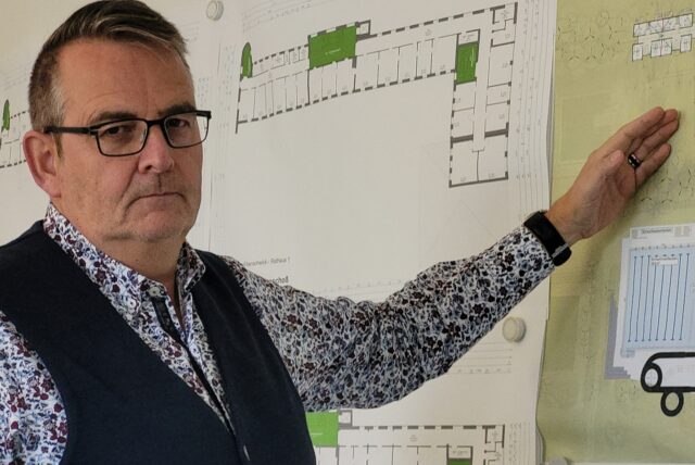 Stadtkämmerer Heinz Schnettger steht vor einem Architektenplan für das Maritimo-Freizeitbad in Oer-Erkenschwick.