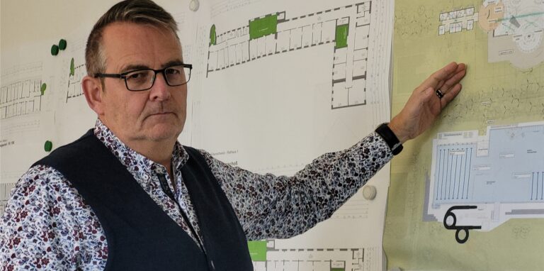 Stadtkämmerer Heinz Schnettger steht vor einem Architektenplan für das Maritimo-Freizeitbad in Oer-Erkenschwick.