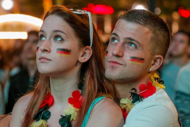 Zwei Fußball-Fans schauen beim Public Viewing zu.