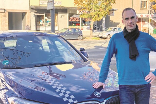 Fahrlehrer Frank Schmidt vor seinem Ausbildungsfahrzeug BMW X1