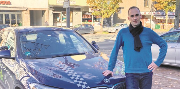 Fahrlehrer Frank Schmidt vor seinem Ausbildungsfahrzeug BMW X1