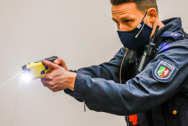 Ein Polizeibeamter führt den Einsatz einer Elektroimpulswaffe, auch Taser genannt, vor. Das Foto ist Anfang 2020 im regionalen Trainingszentrum der Polizei in Dortmund zum Start der Taser-Pilotphase aufgenommen worden.