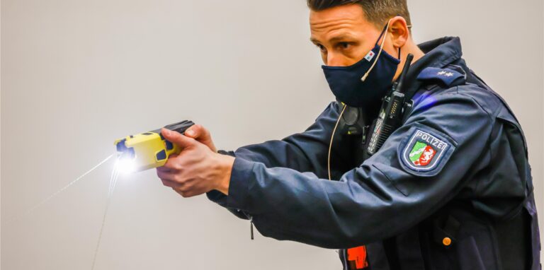 Ein Polizeibeamter führt den Einsatz einer Elektroimpulswaffe, auch Taser genannt, vor. Das Foto ist Anfang 2020 im regionalen Trainingszentrum der Polizei in Dortmund zum Start der Taser-Pilotphase aufgenommen worden.