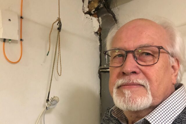 Thomas Exner steht in seinem Keller neben dem Glasfaseranschluss.