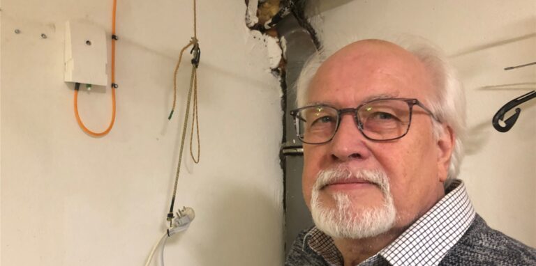 Thomas Exner steht in seinem Keller neben dem Glasfaseranschluss.