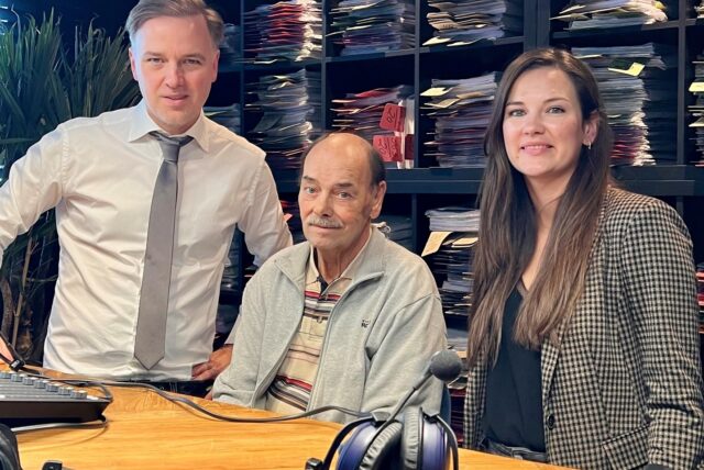 Zwei Männer und eine Frau stehen in einem Studio