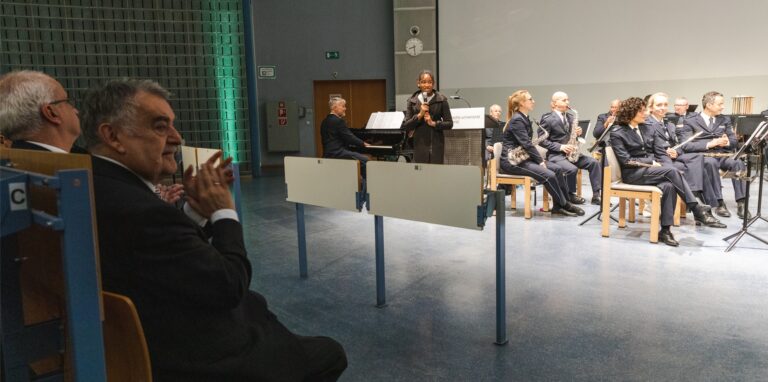 Herbert Reul sitzt applaudierend vor den Musikern.