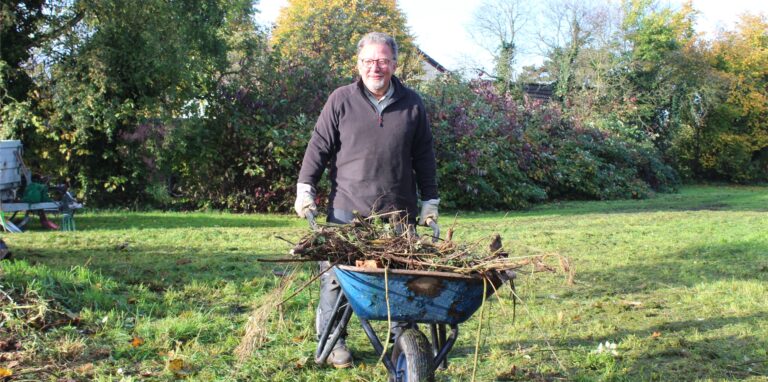 Peter Möller, Anwohner der Grünfläche am Liliencronweg in Waltrop, schiebt eine Schubkarre.