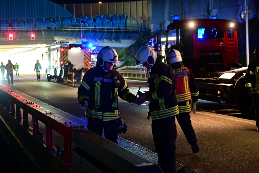 Feuerwehrleute führen vor der Tunnel-Einfahrt eine Notöffnung der Mittelleitplanke durch. Feuerwehrleute führen vor der Tunnel-Einfahrt eine Notöffnung der Mittelleitplanke durch.