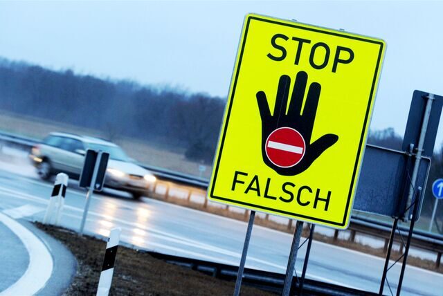 An einer Autobahnausfahrt warnt ein Schild vor dem Weiterfahren in die verkehrte Richtung
