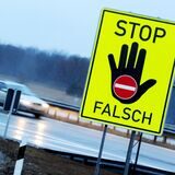An einer Autobahnausfahrt warnt ein Schild vor dem Weiterfahren in die verkehrte Richtung