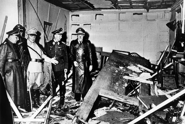 Reichsmarschall Hermann Göring (helle Uniform) und der Chef der „Kanzlei des Führers“, Martin Bormann (l.), begutachten die Zerstörung im Raum der Karten-Baracke im Führerhauptquartier Rastenburg, wo Oberst Stauffenberg am 20. Juli 1944 eine Sprengladung zündete, mit der Absicht Hitler zu töten.