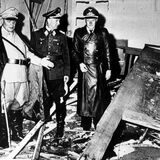 Reichsmarschall Hermann Göring (helle Uniform) und der Chef der „Kanzlei des Führers“, Martin Bormann (l.), begutachten die Zerstörung im Raum der Karten-Baracke im Führerhauptquartier Rastenburg, wo Oberst Stauffenberg am 20. Juli 1944 eine Sprengladung zündete, mit der Absicht Hitler zu töten.