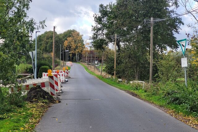 Auf dem Westfeldweg in Oer-Erkenschwick sind Baugruben mit Warnbaken eingezäunt.