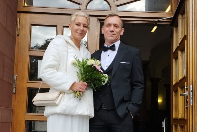 Janina und Michael Naujok stehen nach ihrer Trauung vor dem Dortmunder Standesamt am Friedensplatz.