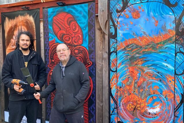 Die Tätowierer Burns Seiken und Heiko Gantenberg (re.) stehen vor einigen der Exponate der Ausstellung „Glaube versetzt Berge“.