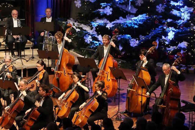Musiker auf einer weihnachtlich geschmückten Bühne