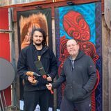 Die Tätowierer Burns Seiken und Heiko Gantenberg (re.) stehen vor einigen der Exponate der Ausstellung „Glaube versetzt Berge“.