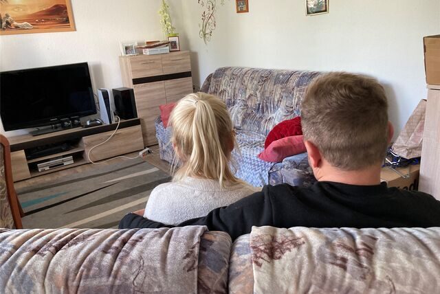 Ein Mann und eine Frau im Wohnzimmer vor dem Fernseher