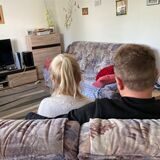 Ein Mann und eine Frau im Wohnzimmer vor dem Fernseher
