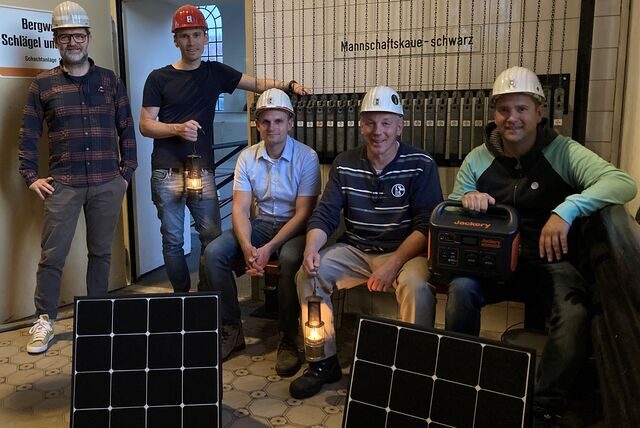 Mitglieder des Fördervereins Maschinenhaus Scherlebeck Schacht 5 zeigen einerseits alte Grubenlampen, andererseits den 1000-Watt-Akkupack und die dazugehörigen Photovoltaik-Module zum Aufladen.