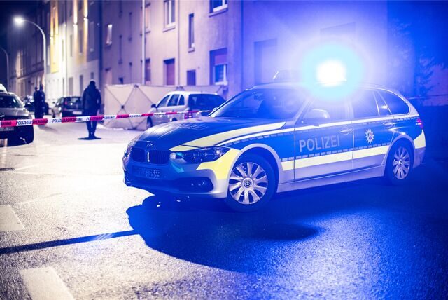 Ein Streifenwagen der Polizei steht vor einer Häuserreihe.