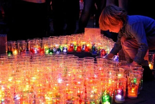 Kind entzündet Teelicht beim Lichterfest in Dorsten