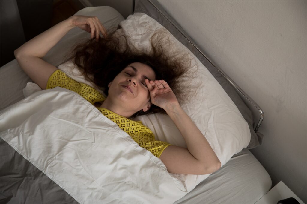 Eine Frau liegt schlaflos im Bett. Eine Frau liegt schlaflos im Bett.