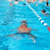 in Badegast schwimmt in einem Freibad.