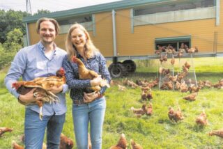 Jan Kenkmann und Hannah Bergmann aus Waltrop mit ihren Hühnern vor dem Hühnermobil.