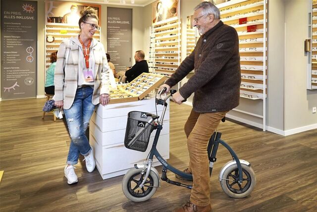 Detlev Lechert, ehemaliger Chef des Arbeitsamtes Gladbeck, ist stets mit einem Laufrad unterwegs, wie man es sonst eigentlich nur von kleinen Kindern kennt. Auch in Geschäften kauft er damit ein, wie hier im Brillengeschäft „Eyes and More“. Mit im Bild: Kundenberaterin Daniela Gogeißl.