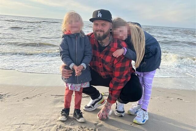 Ein Mann mit Basecap ist mit zwei Mädchen an einem Strand.