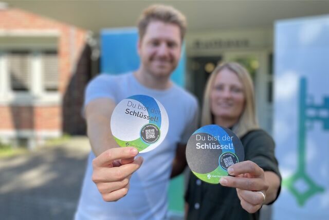 Hanna Hadick und Maurice Schnigge mit Bierdeckeln der Kampagne „Du bist der Schlüssel!“