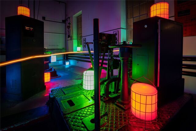Die Steuerung einer alten Bergbau-Fördermaschine wird mit Lampen bunt beleuchtet.