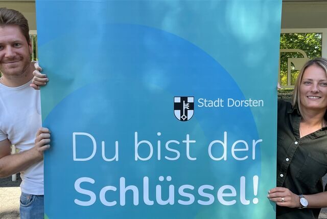 Zwei Mitarbeiter der Stadtverwaltung mit Plakat zur neuen Recruiting-Kampagne