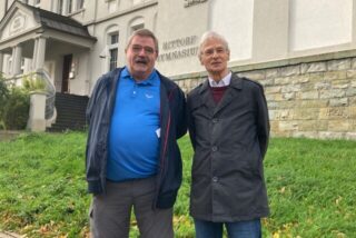 Zwei Männer stehen in Recklinghausen vor der Fassade des Hittorf-Gymnasiums