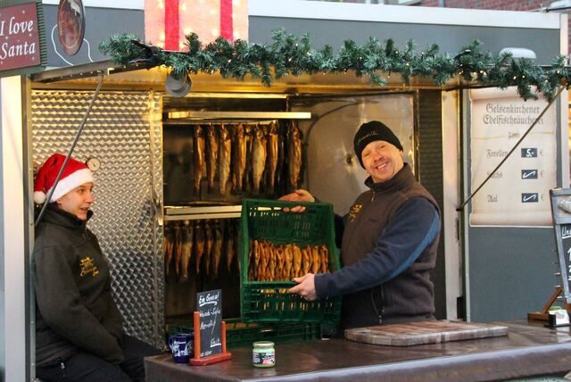 Ein Händler bietet geräucherten Fisch an.