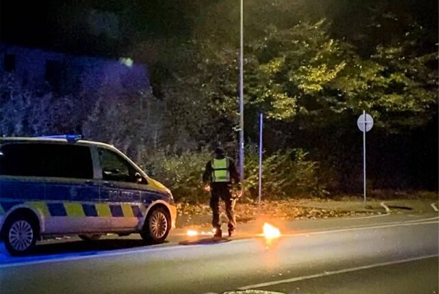 Ein Brandsatz landet vor einen Polizeifahrzeug am Westring