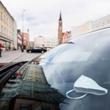 Eine FFP2-Maske liegt auf einem Armaturenbrett von einem Fahrzeug am Stadtplatz.