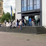 Eine Warteschlange vor einem Gebäude.