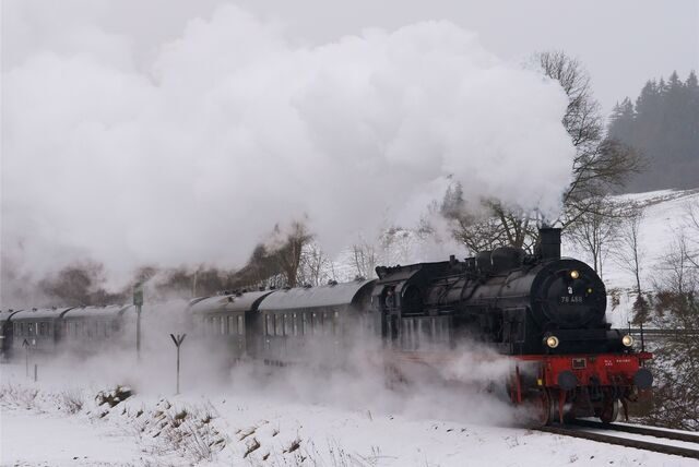 Eine schwarze Dampflokomotive fährt durch eine Schneelandschaft im Sauerland