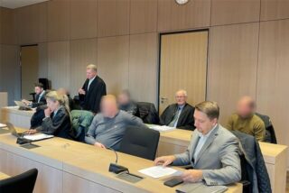 Der Lkw-Fahrer aus Recklinghausen (rechts hinten) und der Staplerfahrer aus Dortmund (hintere Reihe mittig) neben ihren Verteidigern Hans Reinhardt und Winfried Hoff. Rechts vorne sitzt ein Dolmetscher.