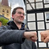 Papatastisch-Autor Thomas Raulf hält seinem Gegenüber zur Begrüßung die Faust entgegen Faustgruß Fistbump