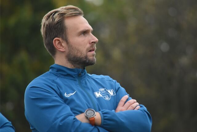 Könoigsborns Co-Trainer Kevin Jagusch steht mit verschränkten Armen am Spielfeldrand und sieht das Spiel seiner Mannschaft.