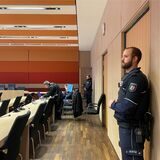 Gerichtssaal mit Polizeibeamten.