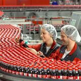 Zwei Arbeiter in einer Coca-Cola-Fabrik