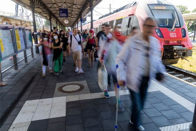 Fahrgäste steigen im Bahnhof aus einer S-Bahn.