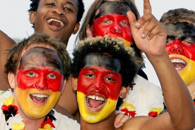 Fußballfans haben sich die Deutschland-Farben ins Gesicht gemalt.