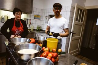 Köchin Beate Abeln und ihr Helfer Alisina Sharifi bereiten in der Gasthaus-Küche 40 Apfelpfannkuchen für das Mittagessen vor.