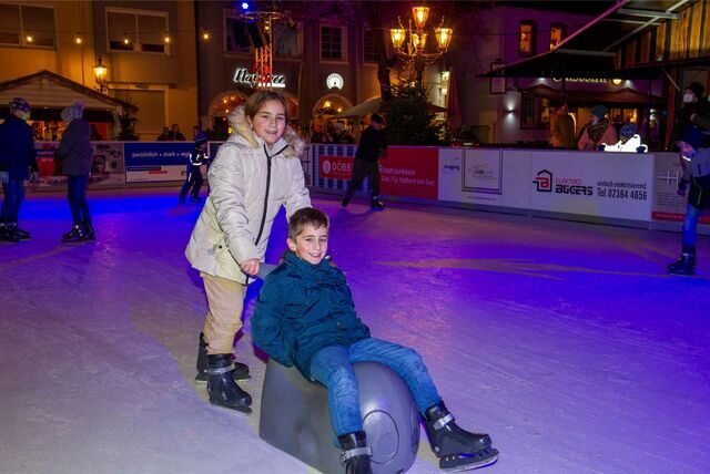 Zwei Kinder fahren auf der Eisbahn in Haltern.